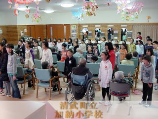 寿幸園の方々の前で歌っている様子です。