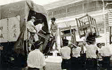 「机や椅子をトラックから運ぶ生徒」の写真２