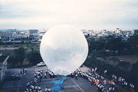 皆が見守る中、上昇しだした熱気球の写真